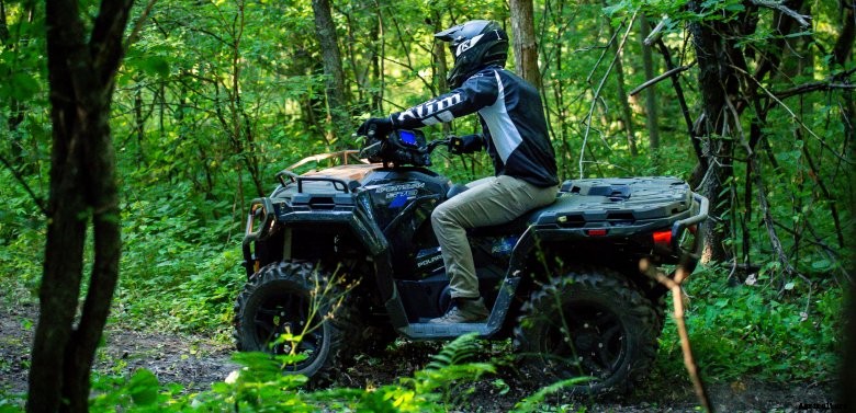Polaris Sportsman driving through the timber